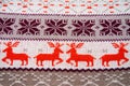 Jacquard knitted pattern. Geometric ornament for Christmas or New Year. Four red deer on a white knitted background