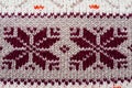 Jacquard knitted pattern. Geometric ornament for Christmas or New Year. Knitted brown snowflakes or flowers on a beige