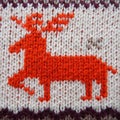 Jacquard knitted pattern. Geometric ornament for Christmas or New Year. Red deer on a white knitted background with