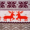 Jacquard knitted pattern. Geometric ornament for Christmas or New Year. Two red deer on a white knitted background