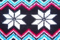 Jacquard knitted pattern. Geometric ornament for Christmas or New Year. Knitted white snowflake, blue pink zigzag on a