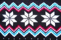 Jacquard knitted pattern. Geometric ornament for Christmas or New Year. Knitted white snowflake, blue zigzag, dots on a