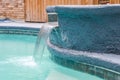 A Jacuzzi Hot Tub Next To A Large Freeform Swimming Pool With A Waterfall Water Feature Running