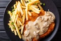 Jaeger Viennese schnitzel with French fries and mushrooms close-up. horizontal top view