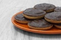 Jaffa cakes biscuits stacked on an orange plate.