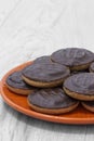 Jaffa cakes biscuits stacked on an orange plate.