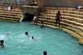 Boys play and bathe in Keerimalai fresh water spring tank by ocean water Jaffna Sri Lanka