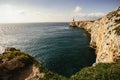 Jagged cliff towering alongside massive ocean