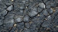 The jagged texture of cracked and uneven asphalt with bits of gravel and debris sticking out