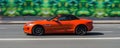 Jaguar F-Type Convertible V8 550 Supercharged AWD on the highway. Orange premium sports car in motion Royalty Free Stock Photo