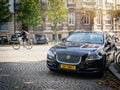 Jaguar luxury black car Golbery apartment building background