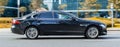 Jaguar XF X260 rides on city road. Side view of black car on asphalt road in motion. Overspeed in city concept Royalty Free Stock Photo