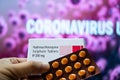 Hydroxychloroquine Sulphate tablets with coronavirus written in background