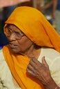 Portrait of a senior woman wearing glasses and orange headscarf at the street in Jaipur, India.