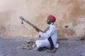 Musician play on traditional music instrument called Kamaycha for tourists on the road in Jaipur, Rajasthan, India Royalty Free Stock Photo