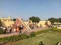 Jaipur, India, November 2019 - A group of people in a garden with Jantar Mantar in the background