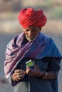 Raditionally dressed unidentified Indian tribal man lights a cigarette by using match