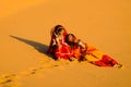 Indian village women sitting in desert sand dune wearing ethnic traditional Royalty Free Stock Photo