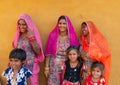 Smiling and happy Rajasthani women and children in local costume, posing in a Rajasthani village