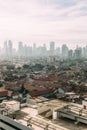 Jakarta Cityscape with high rise, skyscrapers and red tile hip roof local buildings with fog in the morning