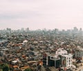 Jakarta Cityscape with high rise, skyscrapers and red tile hip roof local buildings with fog in the morning