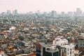 Jakarta Cityscape with high rise, skyscrapers and red tile hip roof local buildings with fog in the morning