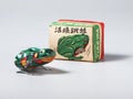 Vintage frog tin toy with its packaging box as background