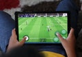 Man playing PES game on Tablet