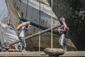 Jakarta, Indonesia - July 13, 2009: unskilled workers loading sacks with cement onto a wooden transport vessel