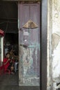 Young boy watches from behind an old door in Jakarta