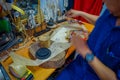 JAKARTA, INDONESIA: Local handcraft worker sitting by workplace desk using his tools creating traditional art