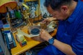 JAKARTA, INDONESIA - 3 MARCH, 2017: Local handcraft worker sitting by workplace desk using his tools creating