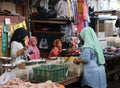 Indonesian Muslim housewife buying vegetable from female street vendor in the fresh market at Jakarta