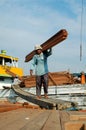 Laborers are transporting wood from trucks to ships at Sunda Kelapa Harbor, Jakarta - Indonesia