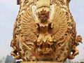 Jakarta, July 30-2023 : Taking a close-up photo of the gold-painted relief carving of a jatayu bird in a large flower vase