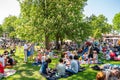 Summer garden view of groups with many people and families outdoors at a green field having picnic on the Swedish national day.