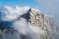 Jalovec ridge in the Julian Alps, Triglav National Park, Slovenia, with misty clouds and blue sky. Climbing, mountaineering.