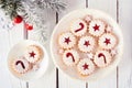 Jam filled Christmas cookies, top view on a marble plate against white wood