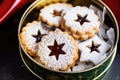 jam-filled linzer cookies in a cookie tin