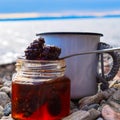 Jam from fir cones in a jar on the background of the lake.  Home-made jam from pine cones. Selective focus. Royalty Free Stock Photo