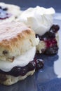 Jam and fresh cream scone on blue plate