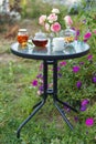 Jam in glass jar. Romantic dinner in the garden under a rose bush. Royalty Free Stock Photo