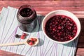 Delicious sweet dessert, jam, black currant and red gooseberries in jar and bowl. Royalty Free Stock Photo