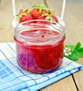 Jam of strawberry with a basket on the board Royalty Free Stock Photo