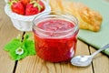 Jam of strawberry with bun and basket on board Royalty Free Stock Photo