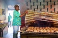 Jamaican cook showing jerk chicken cooking