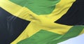 Jamaican flag waving at wind with blue sky in slow, loop