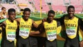 Jamaican 4x100 relay team running with flags after winning silver on the IAAF World U20 Championship in Royalty Free Stock Photo