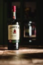 Jameson whiskey bottle on wooden table in dark bar