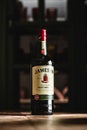 Jameson whiskey bottle on wooden table in dark bar